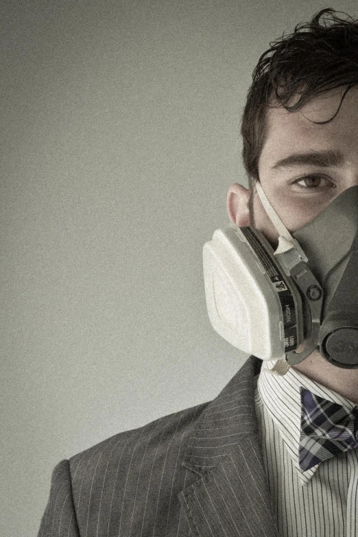 a man in a suit with a respirator attached to his nose