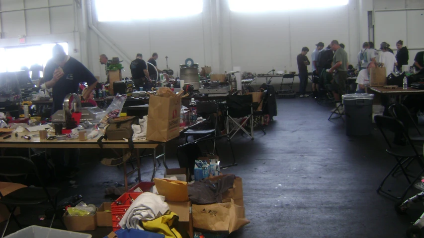 people in a room filled with various objects and boxes