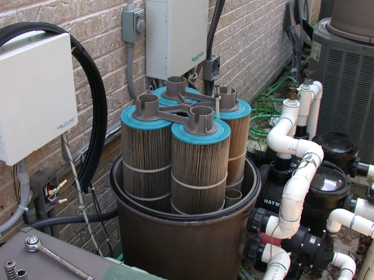 a group of air conditioners sitting next to a brick wall