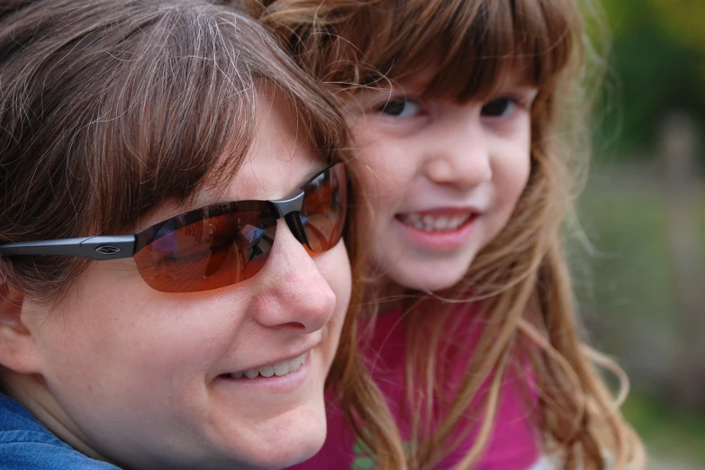 two women wearing sunglasses pose for a picture