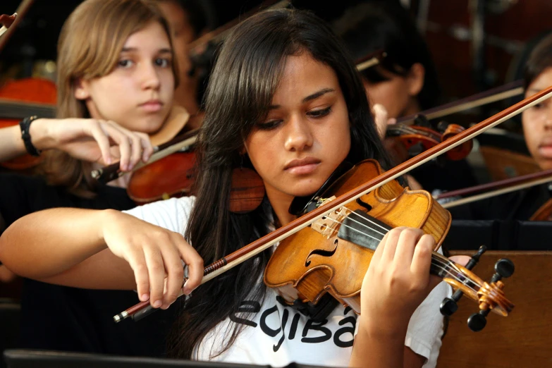 a young woman playing a violin in a orchestra