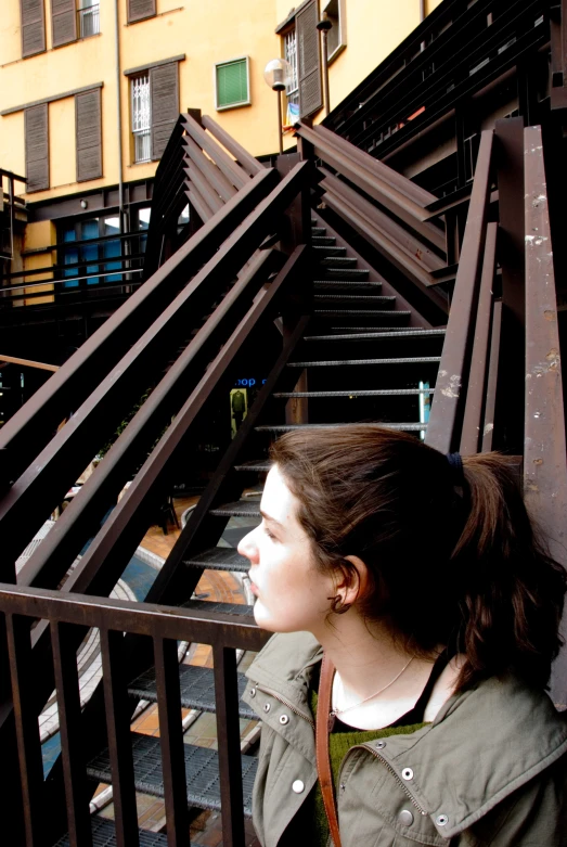 a woman is standing on stairs near buildings