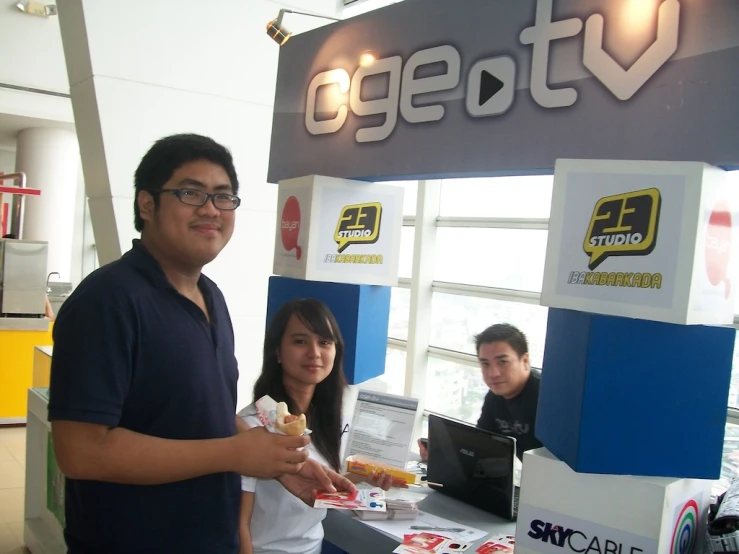 people are standing near a sign showing gesti tv