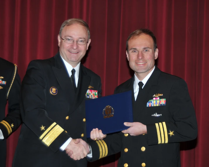 two military men in uniform shaking hands