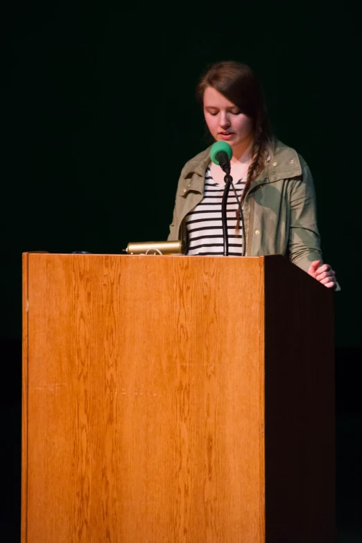 a woman standing at a podium with a microphone in front of her