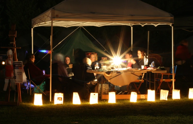 an outdoor tent with people sitting at it