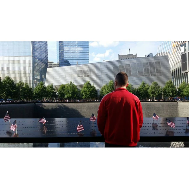 a man standing in front of a wall with american flags on it