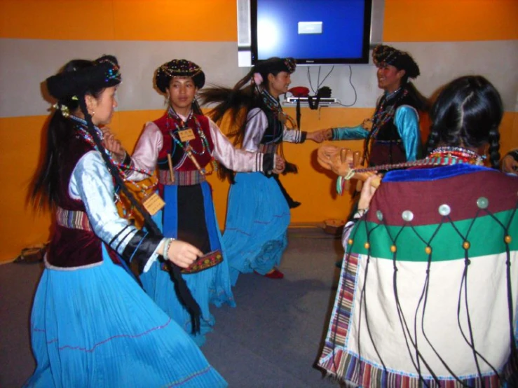 a group of people in native garb are playing violin