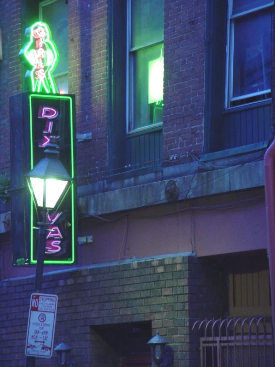 a neon sign for a pimp bar sits on the corner