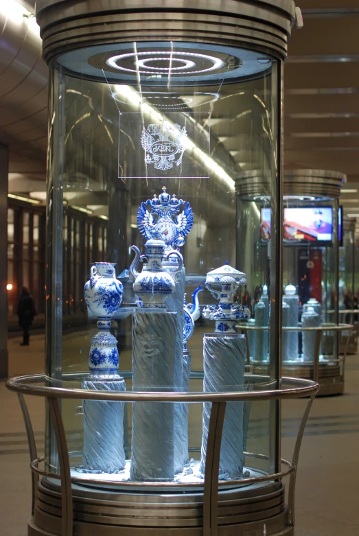 an elegant display case with multiple vases on it