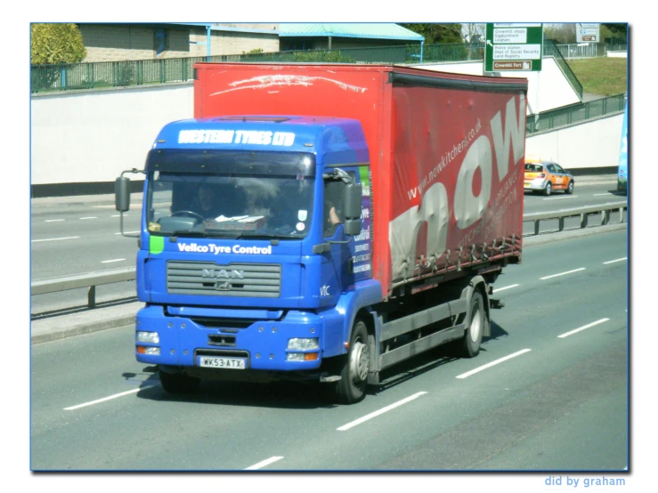 a large red and blue semi truck on the road