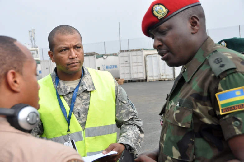 a soldier talks with two men in uniform