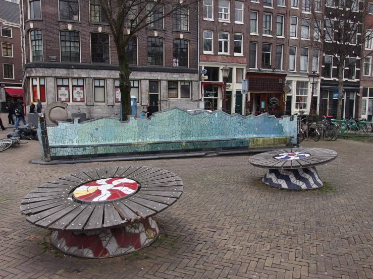 some benches in the middle of a park near a bunch of buildings