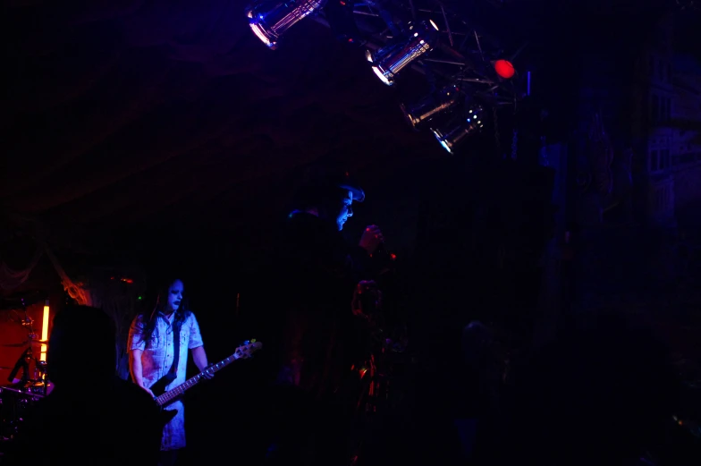 people playing instruments in the dark at a concert