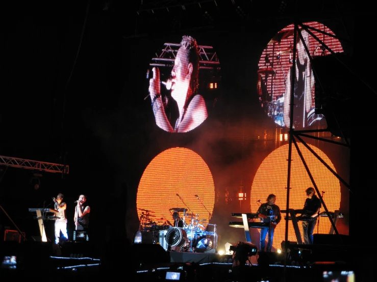 three large displays are projected onto the stage during the show