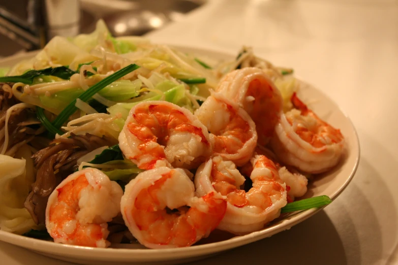 a white plate filled with some shrimp and noodles