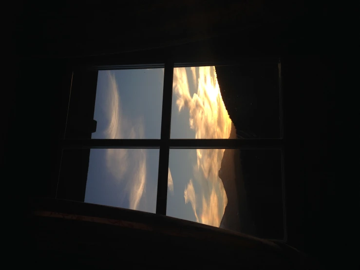 the sky is covered in clouds from the window