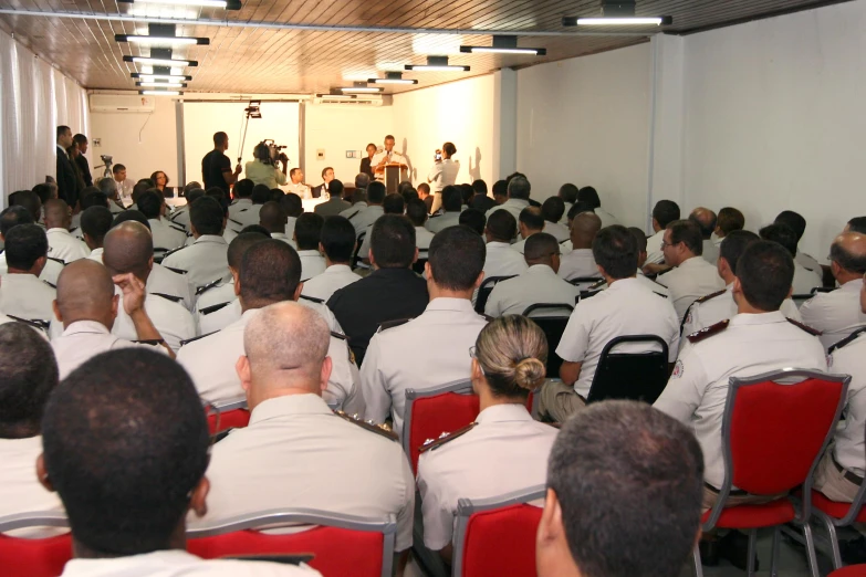 a room with several military officers at their positions in a panel meeting