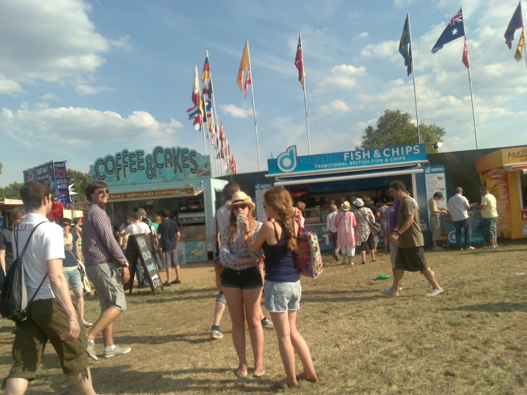 two woman looking at their cell phones in front of a booth