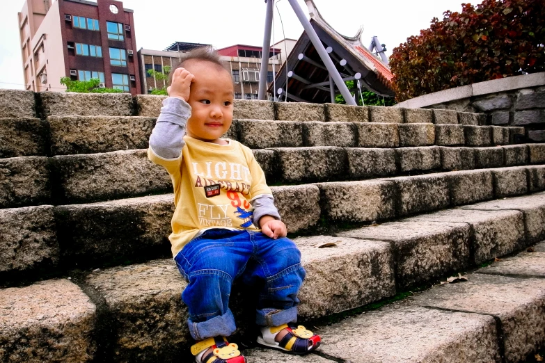 a young child sitting on the steps outside