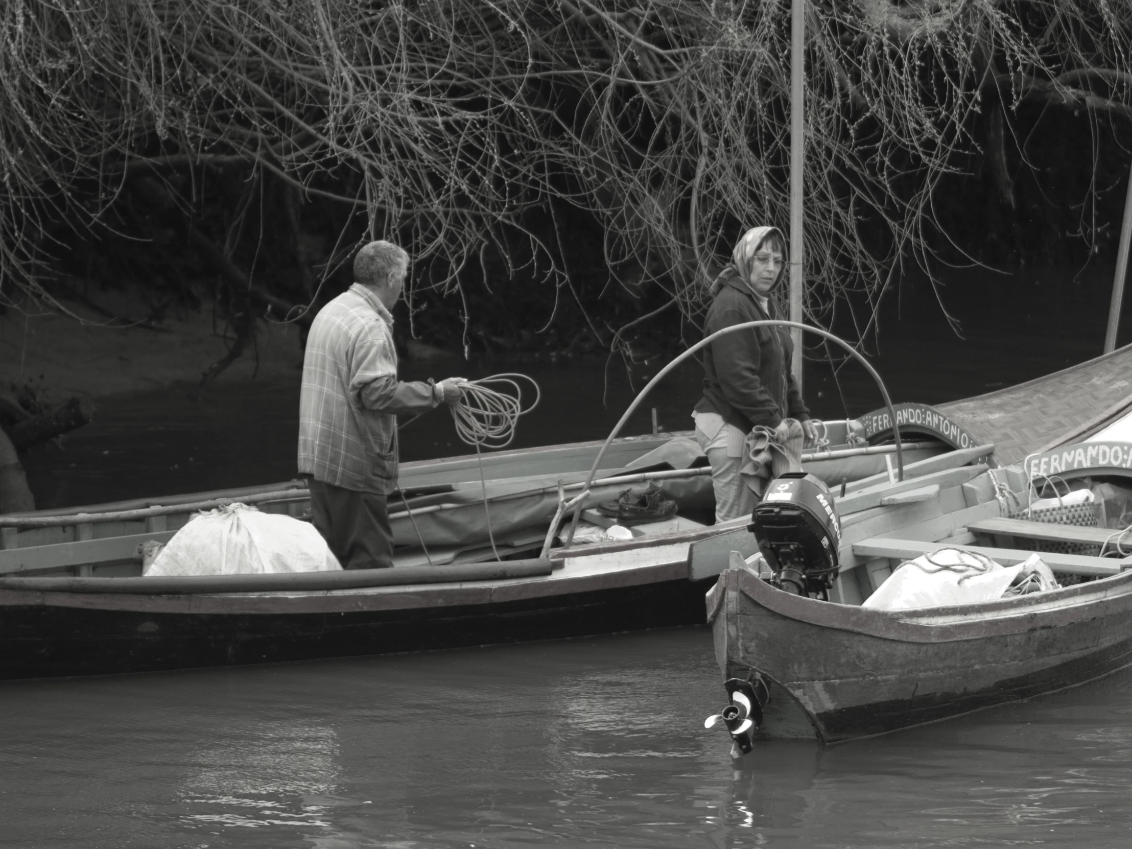 two men standing on the bow of their boats