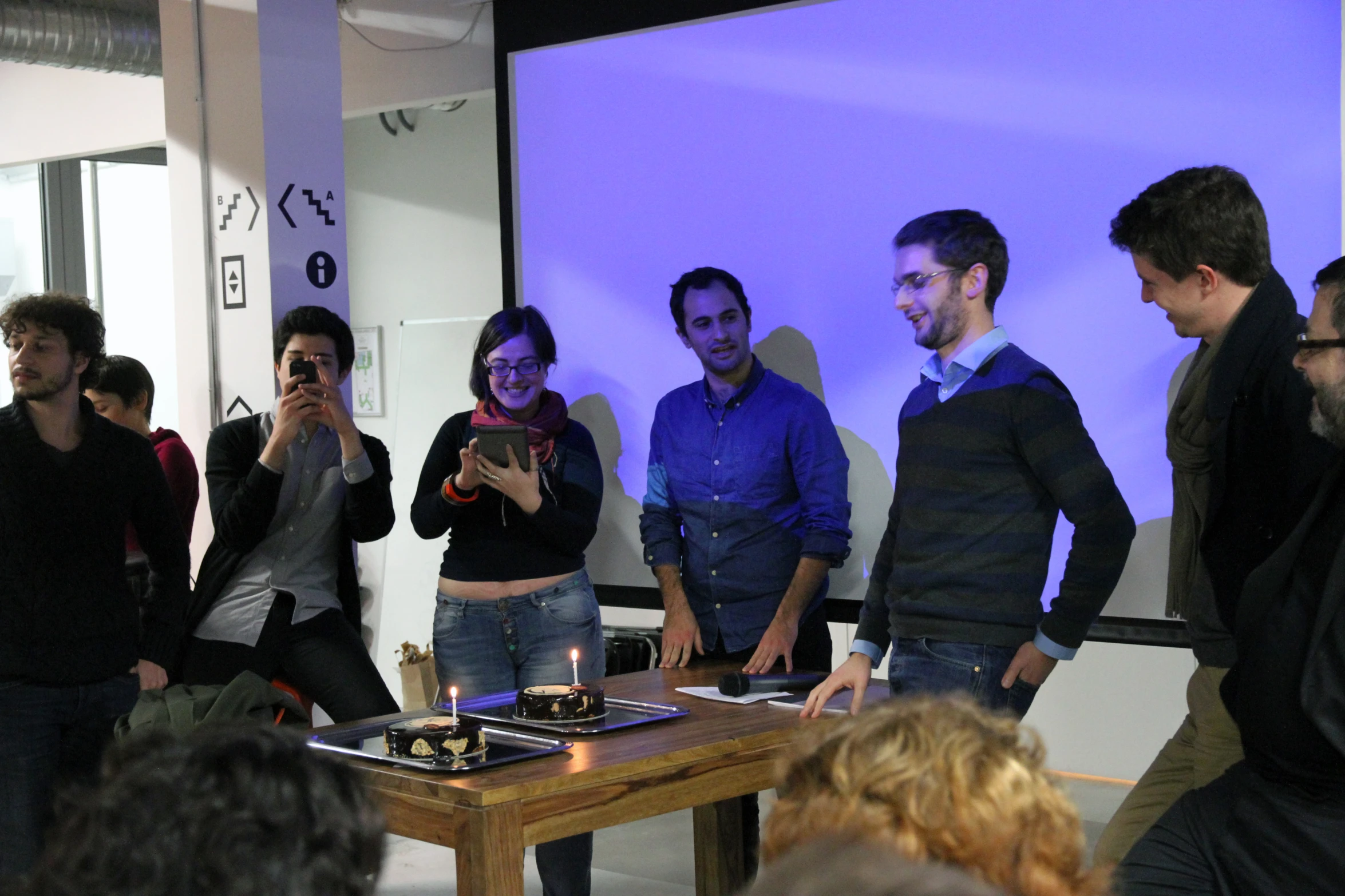 a group of people looking at a cellphone