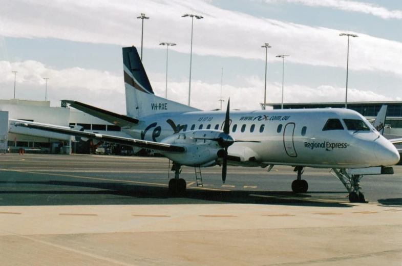 a silver airplane is sitting in an airport runway