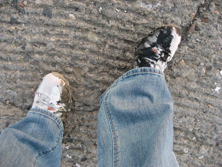 close up of a person's feet standing on the side walk