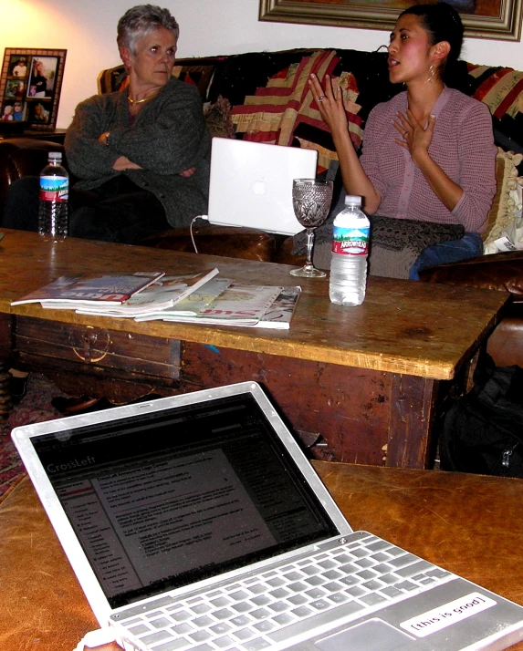 a laptop is being displayed near a wooden table