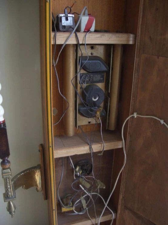 this is an odd looking old book shelf with some electrical wires