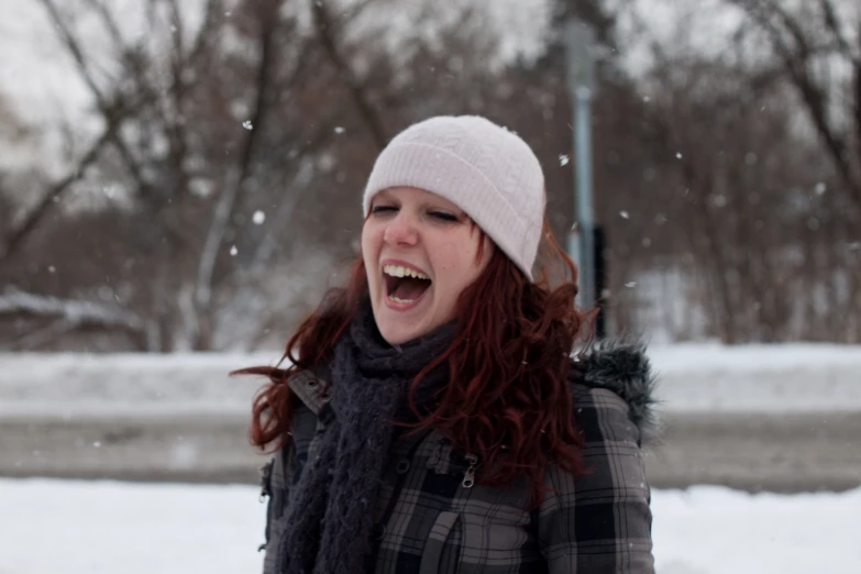 a woman smiling and laughing while standing in the snow