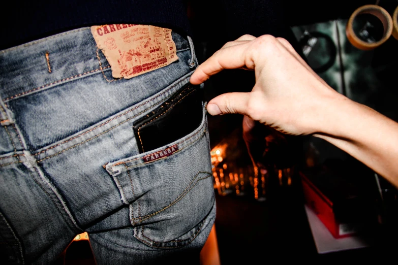 a person pulling a cell phone out of the pocket