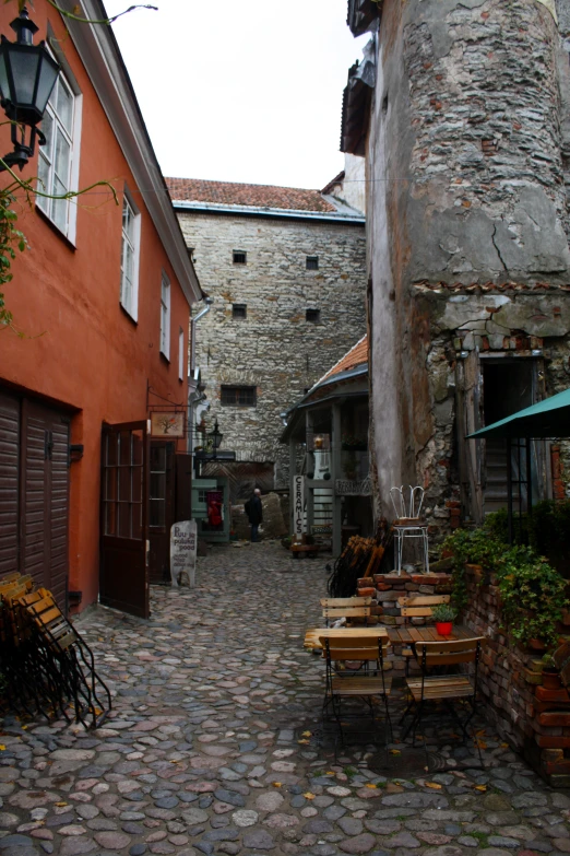 a cobbled street with tables outside of several buildings