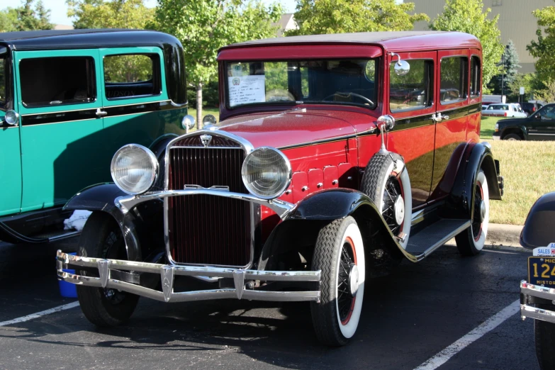 an antique truck sits parked in the lot near others