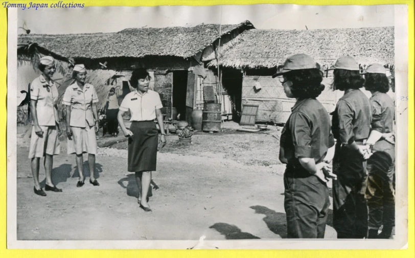 vintage po of man and woman walking in front of hut