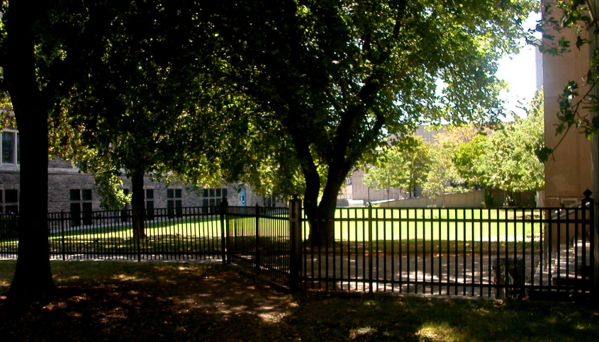 the gate is near a green lawn and some trees