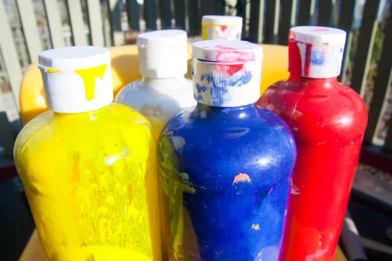 five bottle of liquids sitting on top of a wooden table