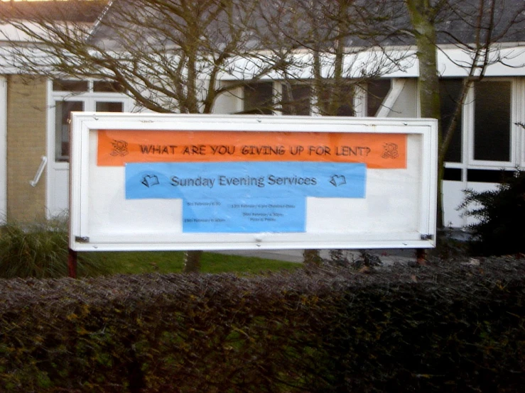 a sign for a dentist in front of two small houses