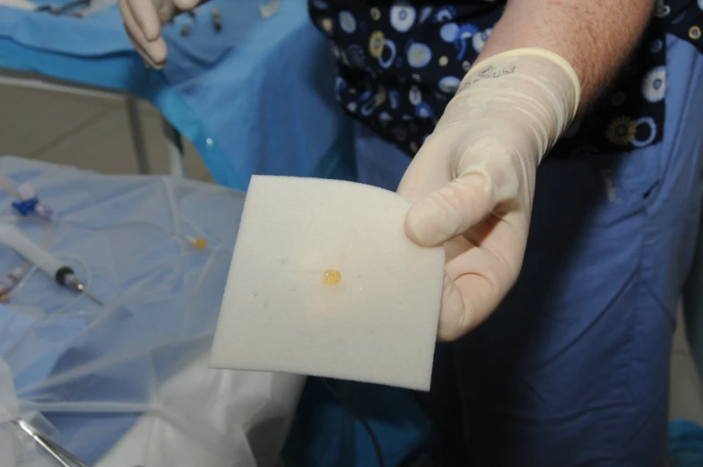 a person in blue gloves holding a piece of paper with writing on it