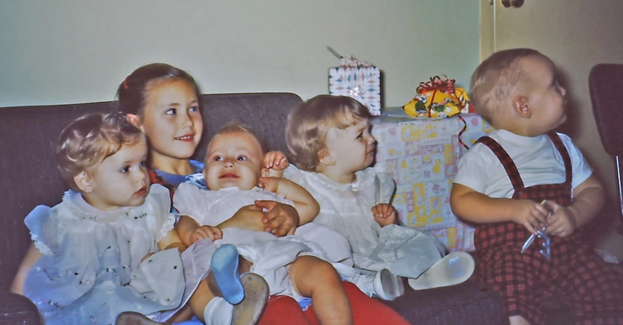 the six children are sitting on a couch