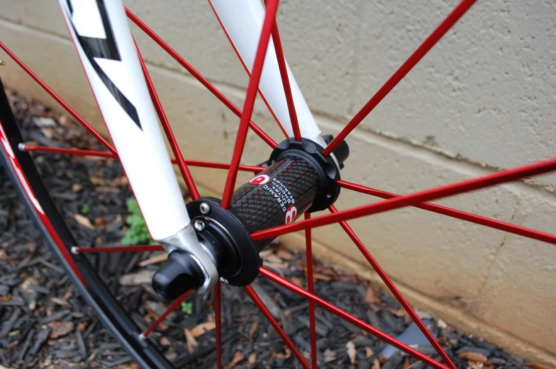 a close up of a red bike spoke with the seatpost visible