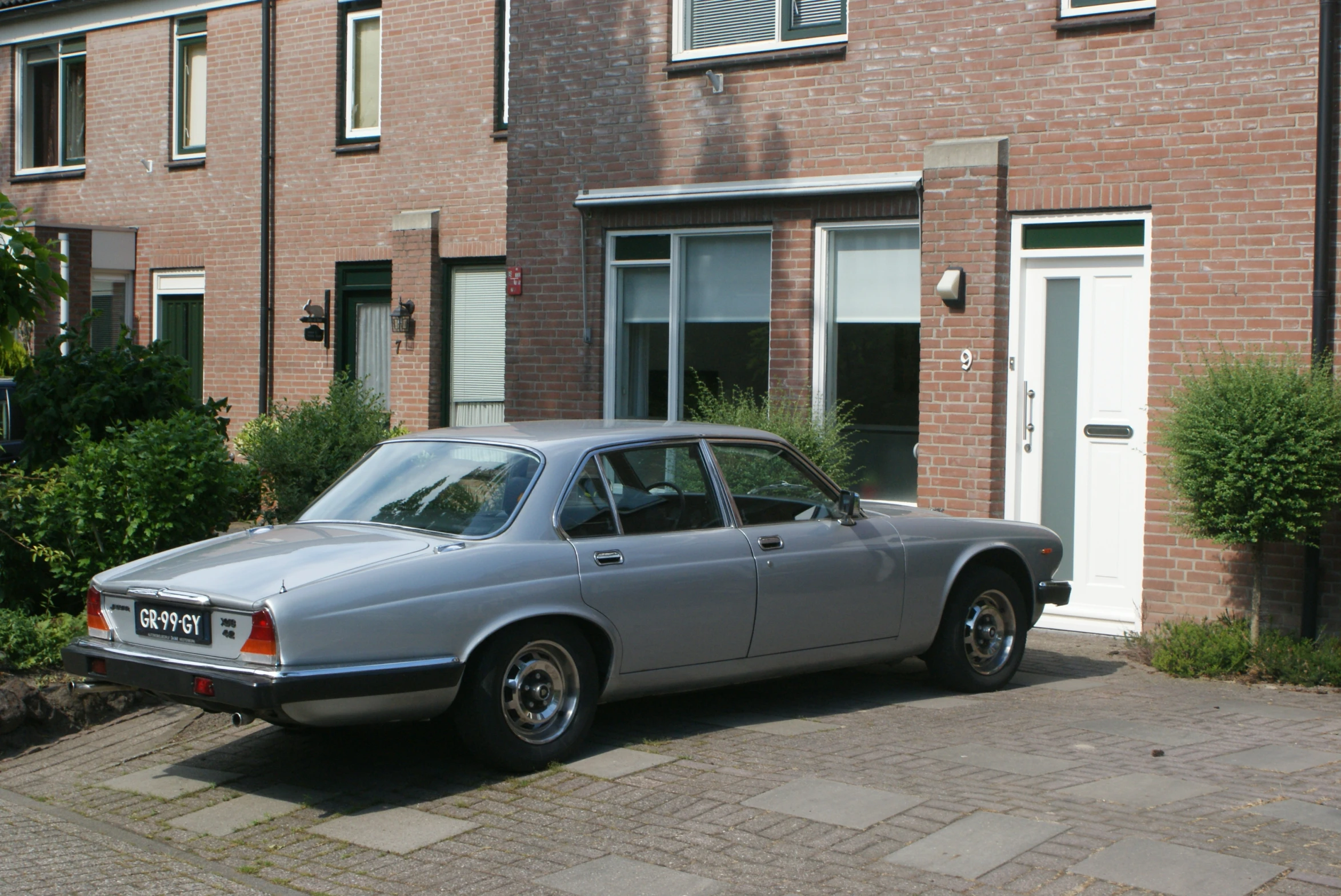 an old car sits parked in front of a house