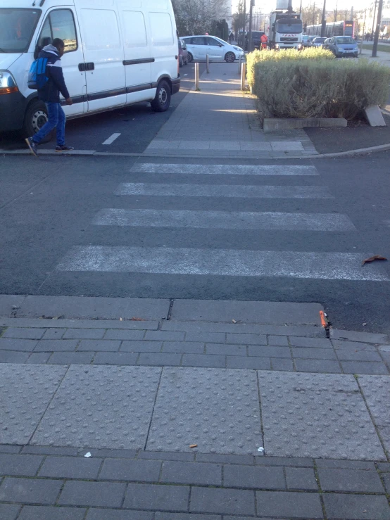 a man riding a skateboard across a cross walk