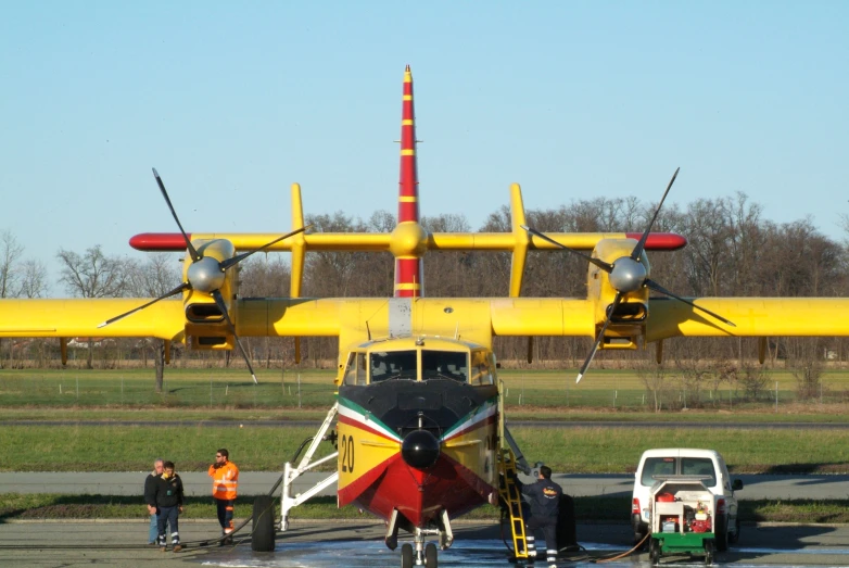 the two propeller airplane has been painted red, yellow, and green