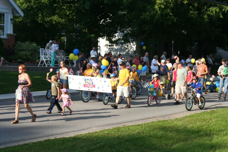 people are carrying a banner and bicycle in the street