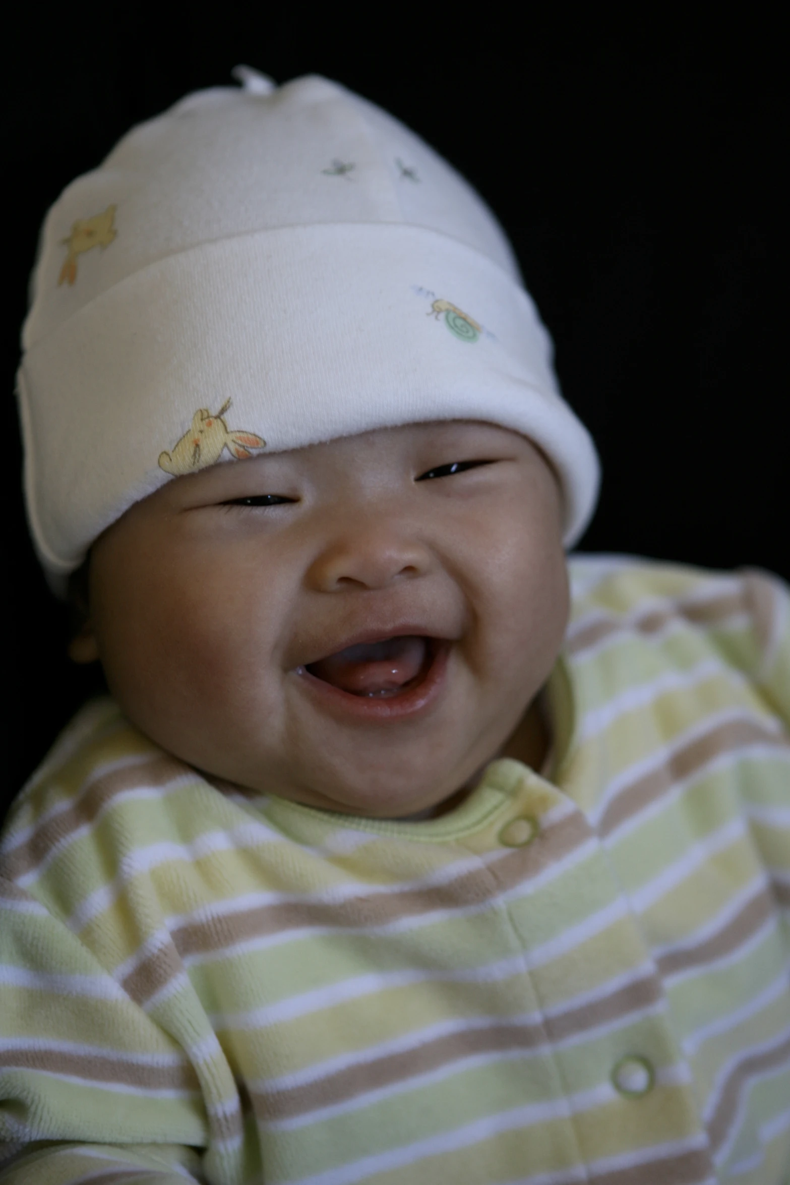 a smiling baby with a white hat