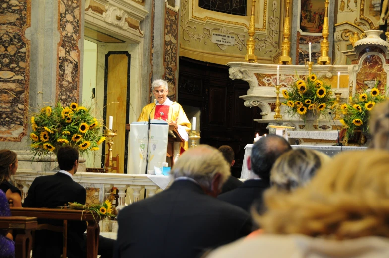 the priest is speaking in front of a crowd