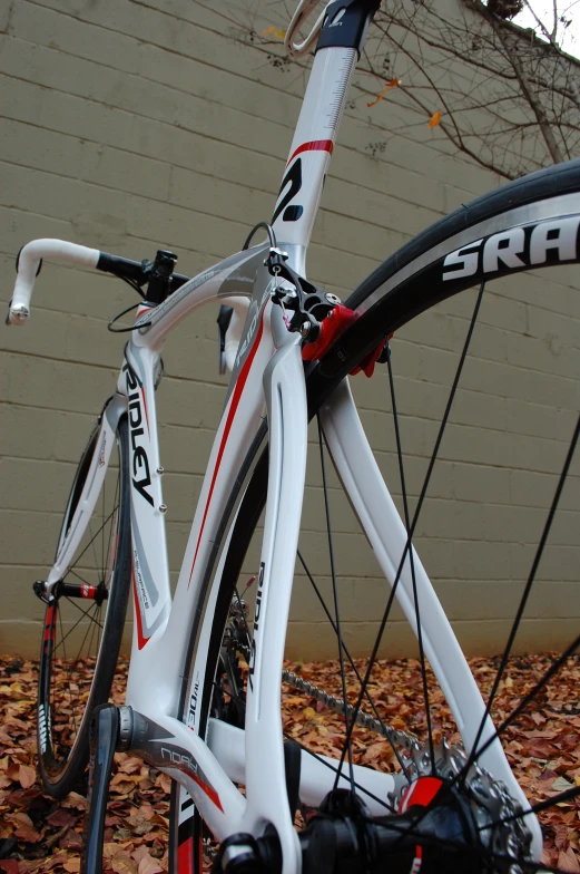 a white bicycle with red writing and an arrow forked on the front of it