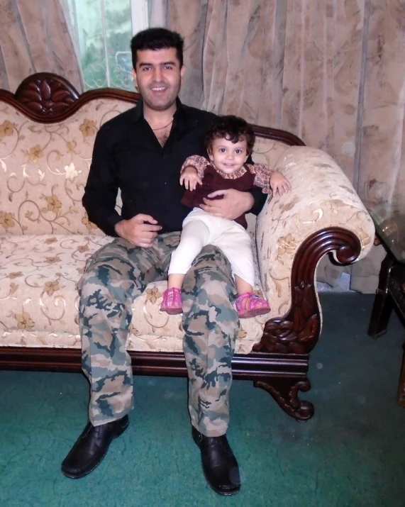 man and child sitting on brown wooden bench