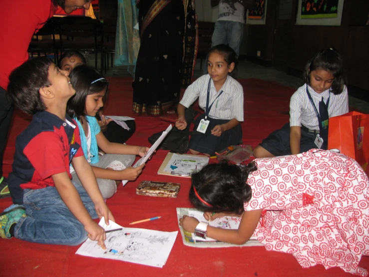 several s sit at a table with paper and pencil